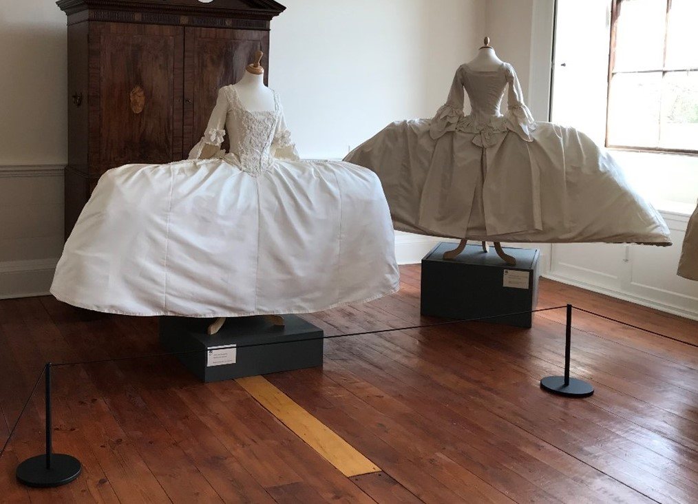 Two cream Mantua dresses in the ‘A Dress Fit for a King’ exhibition at Berrington Hall, protected by black Absolute Freestanding Barriers and cord. Two cream Mantua dresses in the ‘A Dress Fit for a King’ exhibition at Berrington Hall, protected by black Absolute Freestanding Barriers and cord.