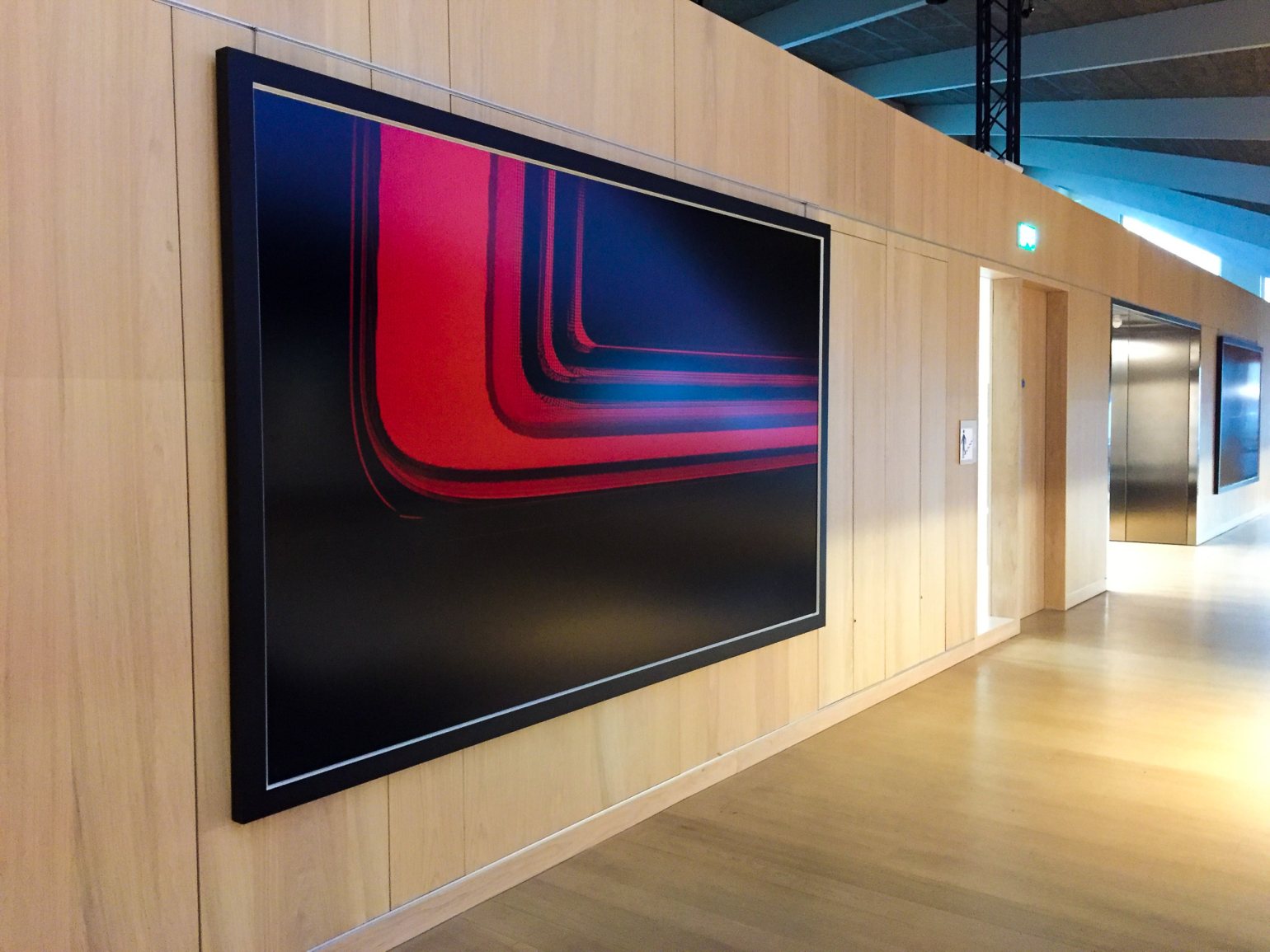 Large artwork hanging from a wall using Absolute track hanging systems for discreet & secure artwork hanging. The Design Museum, London.  Large artwork hanging from a wall using Absolute track hanging systems for discreet & secure artwork hanging. The Design Museum, London.