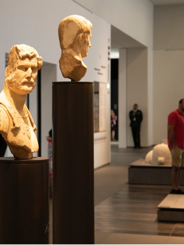 Two historic stone sculptures of the heads of two different men on display at Louvre Abu Dhabi. Two historic stone sculptures of the heads of two different men on display at Louvre Abu Dhabi.