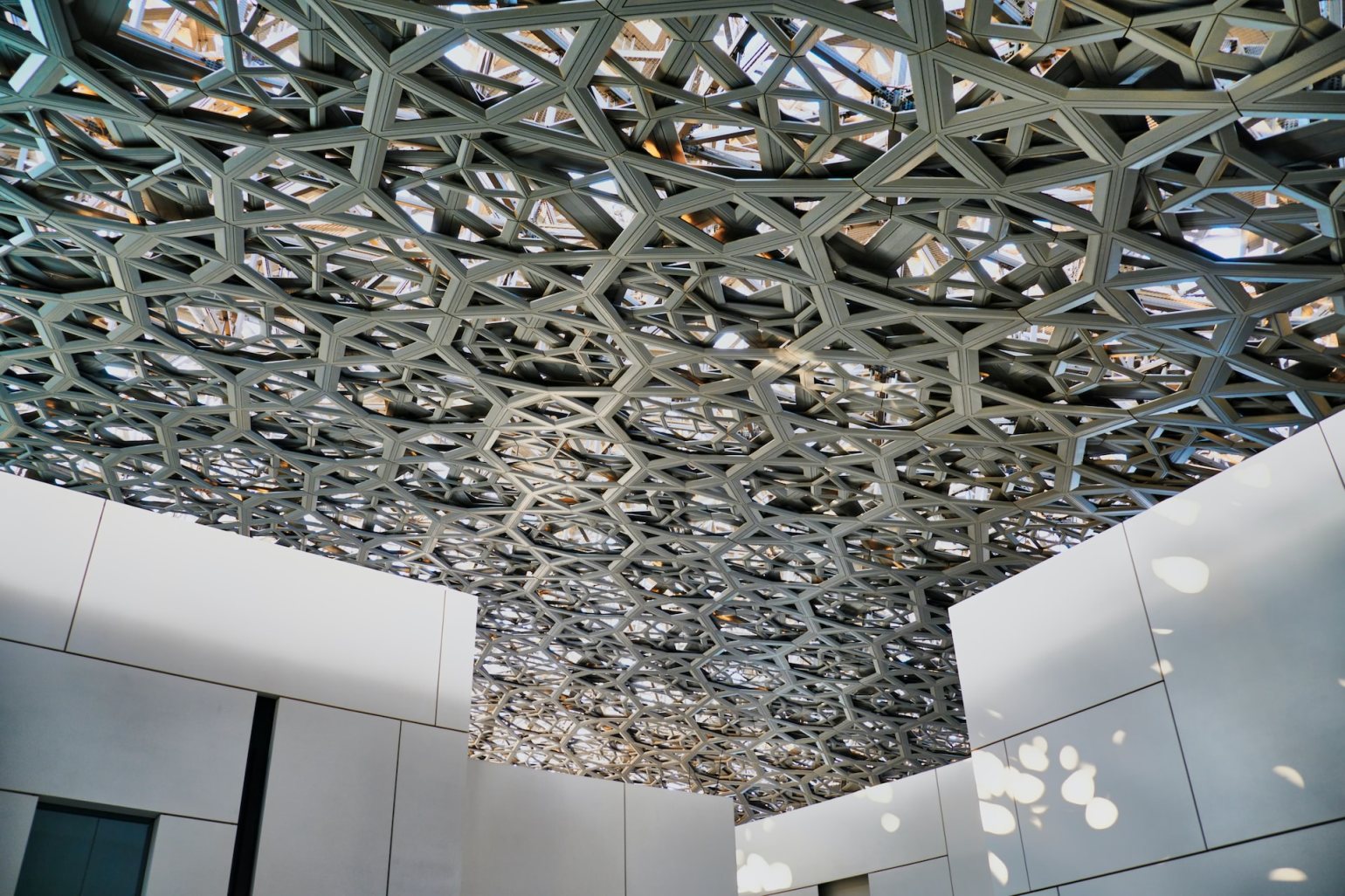 Interior close-up of the stainless steel and aluminum star dome of Louvre Abu Dhabi, designed by Jean Nouvel.