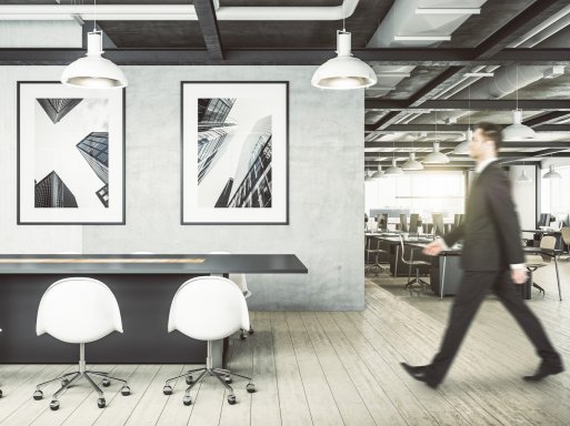 Office with artworks hanging on the wall, man walking past. Office with artworks hanging on the wall, man walking past.